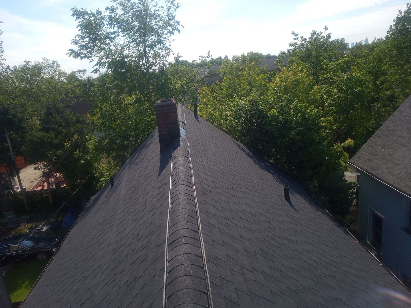 A long new shingle roof ridge running into the distance