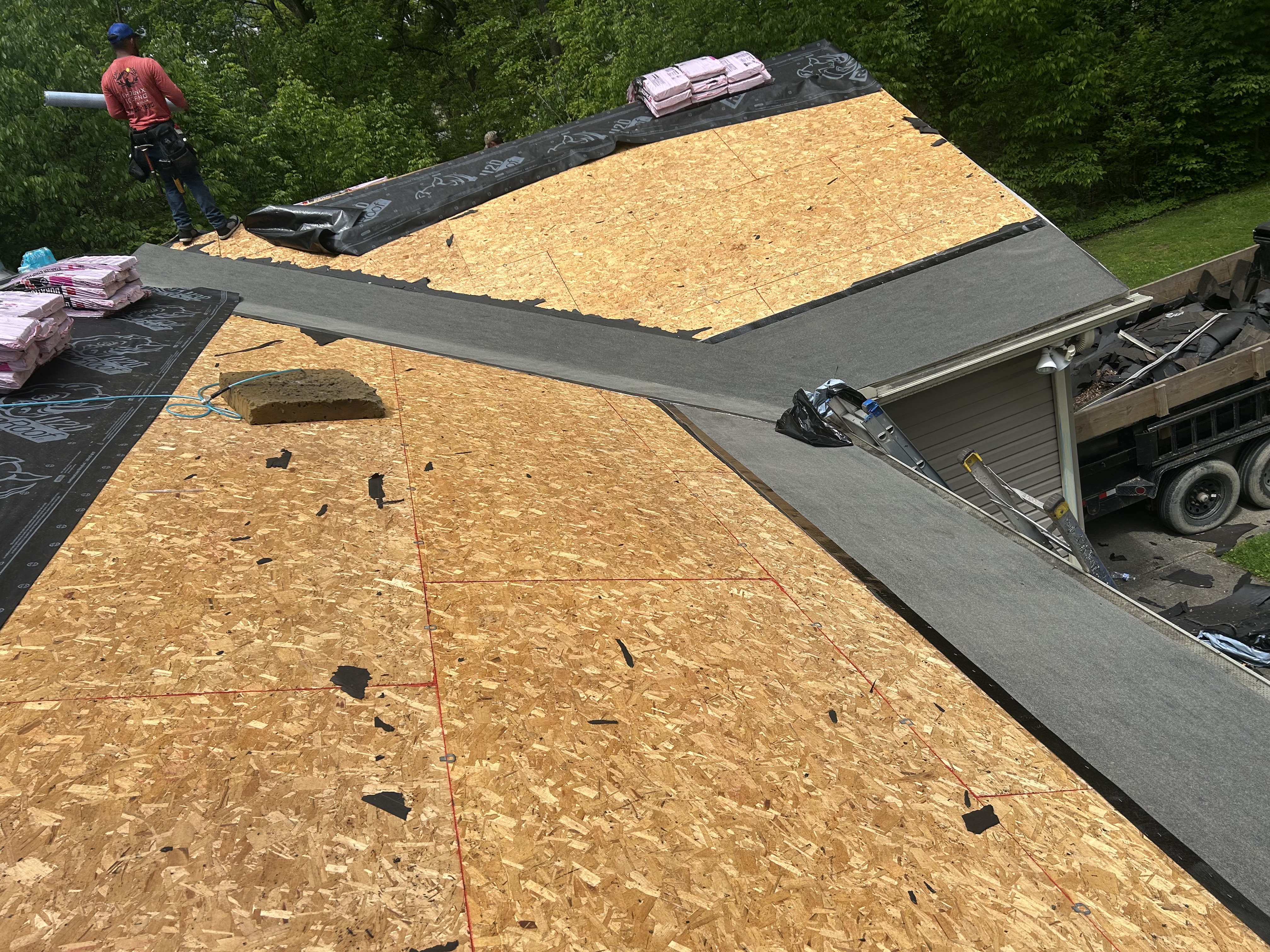 A roof mid-replacement with new decking, tools and a materials lift