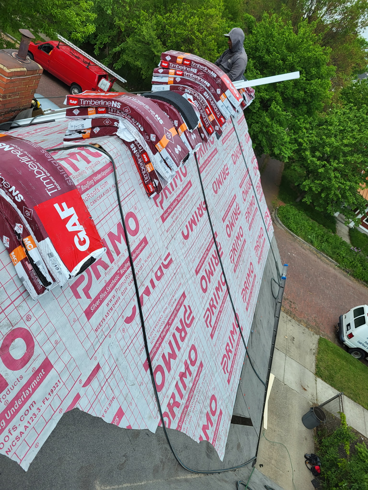 A steep roof mid-installation with GAF shingles and Rhino synthetic underlayment