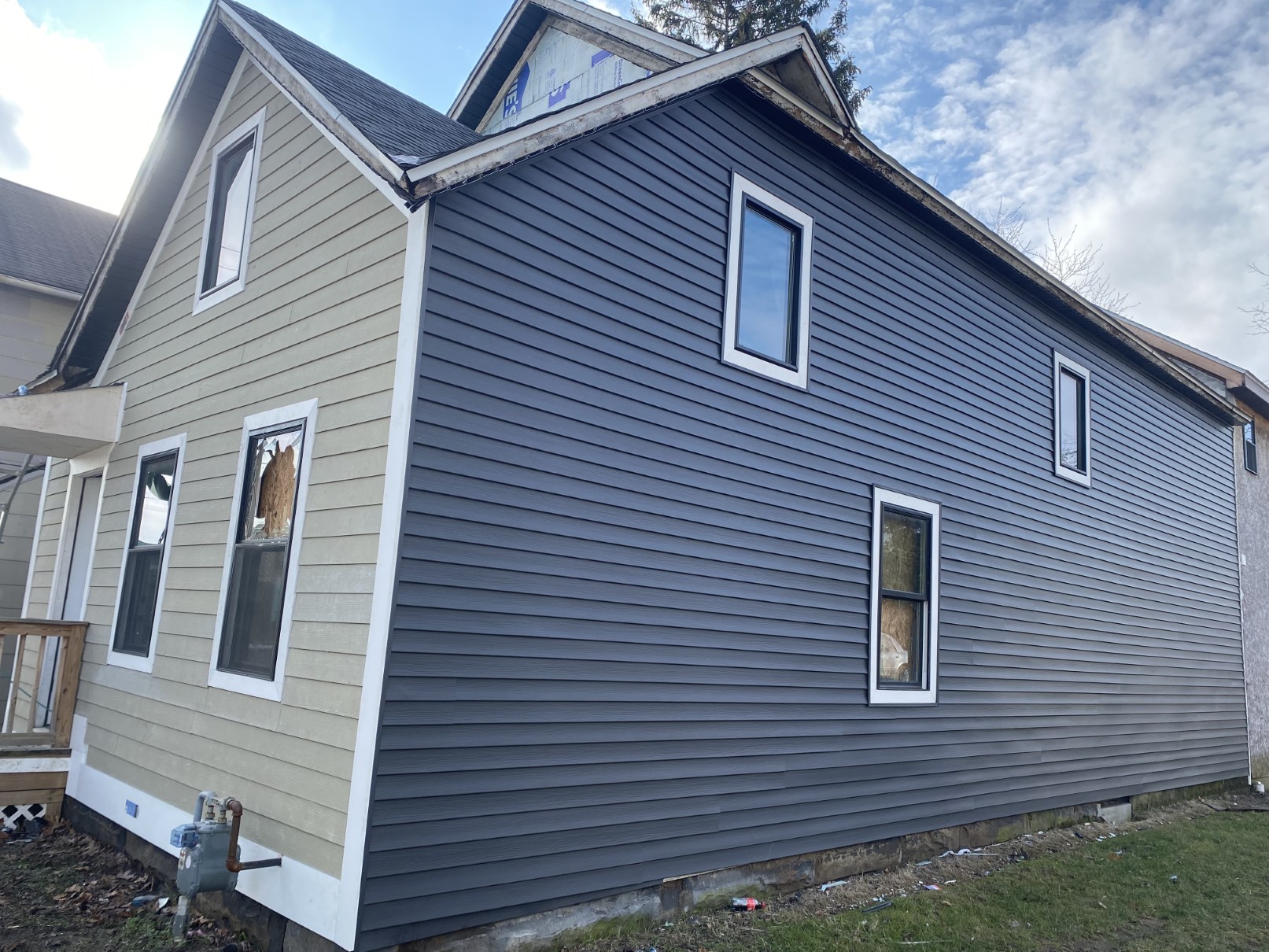 A two-story home with blue-grey lap siding